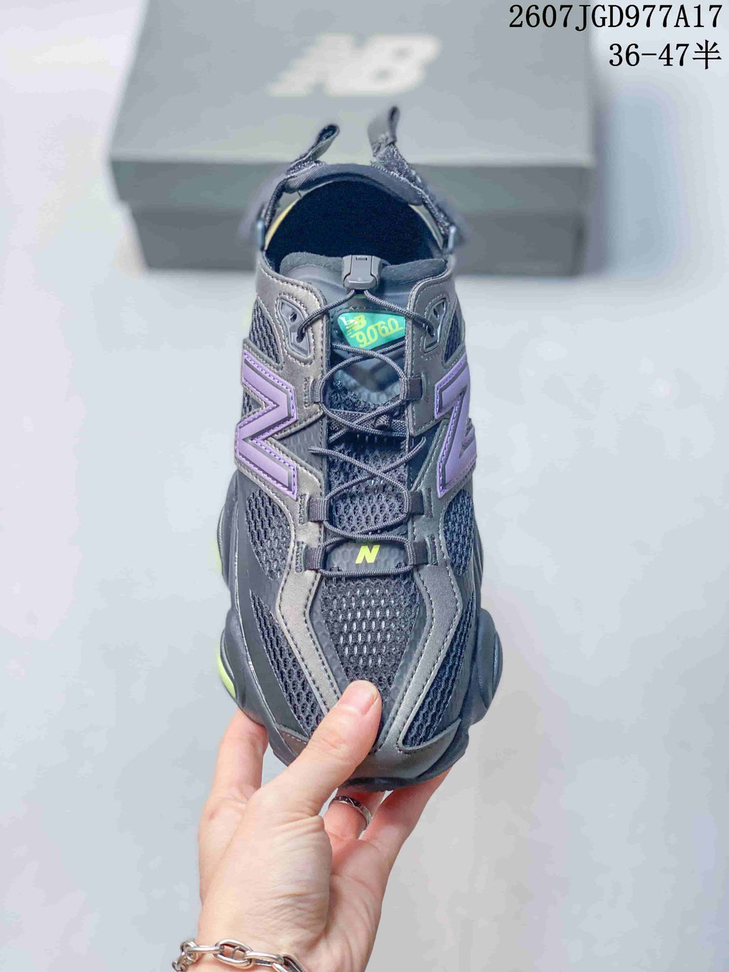 Top view of a black New Balance 9060 sneaker showing the mesh upper, layered purple side branding, laces and tongue label.