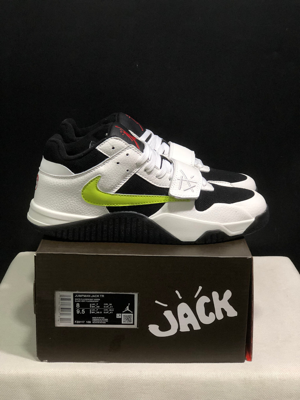 Side view showing the white upper, black panels, fluorescent green side detail, and black outsole.