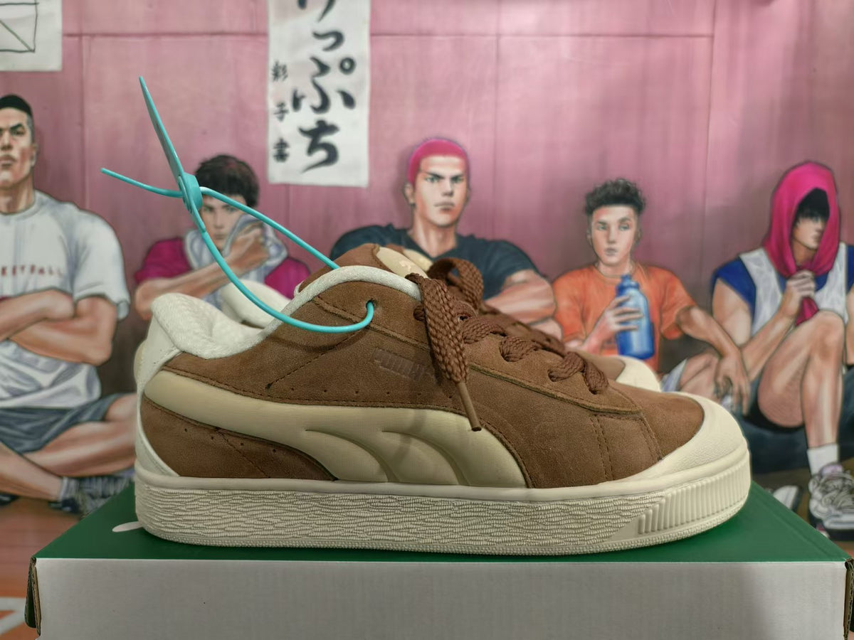 Side profile of a brown PUMA sneaker showing cream side detailing and a textured sole
