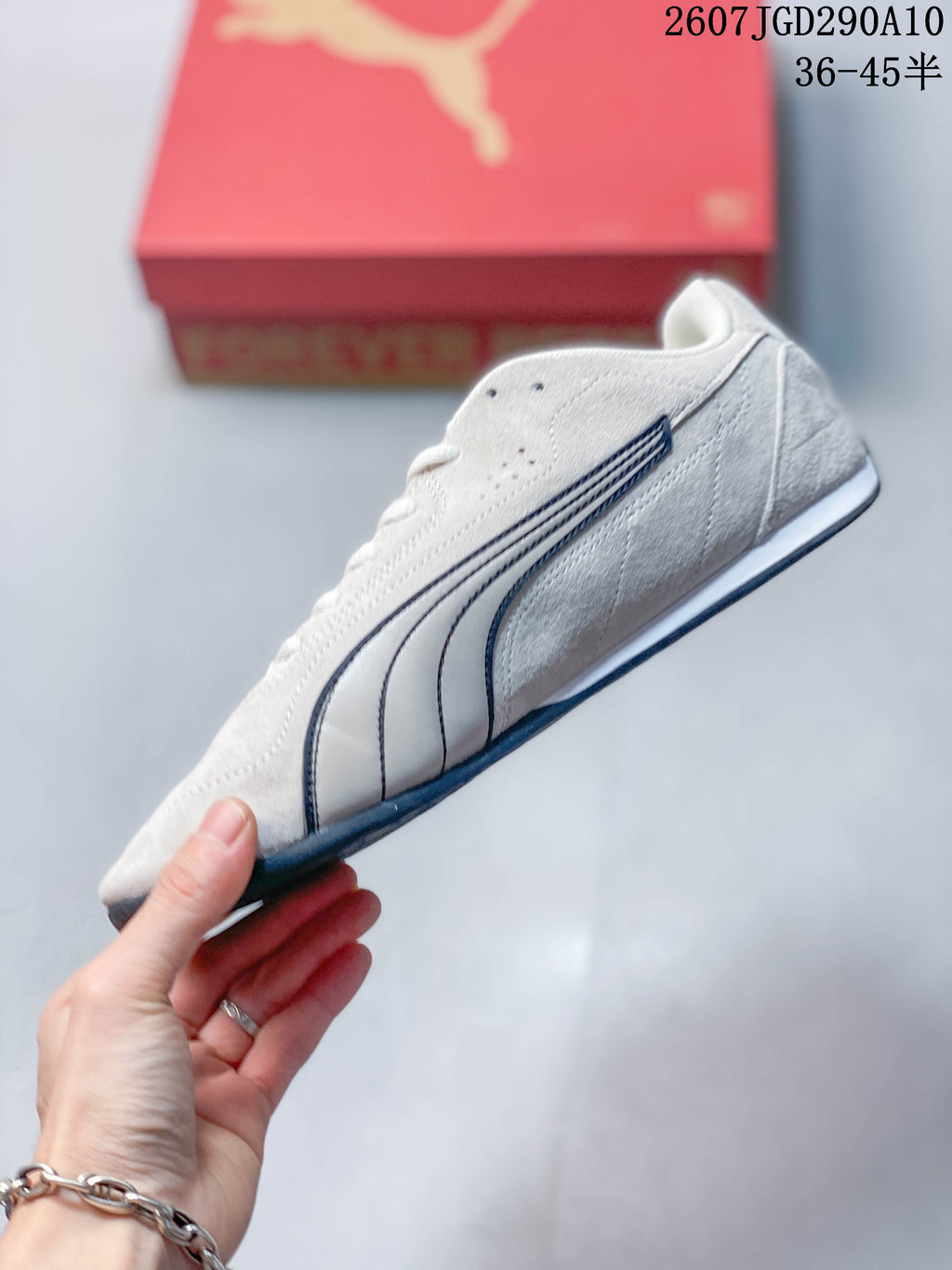Side profile of the white low-top sneaker with dark stitched side branding and a slim outsole.