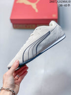 Side profile of the white low-top sneaker with dark stitched side branding and a slim outsole.