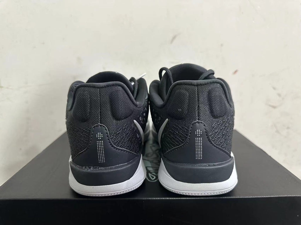 Rear view of black low-top basketball shoes with white midsoles
