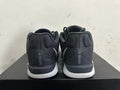 Rear view of black low-top basketball shoes with white midsoles