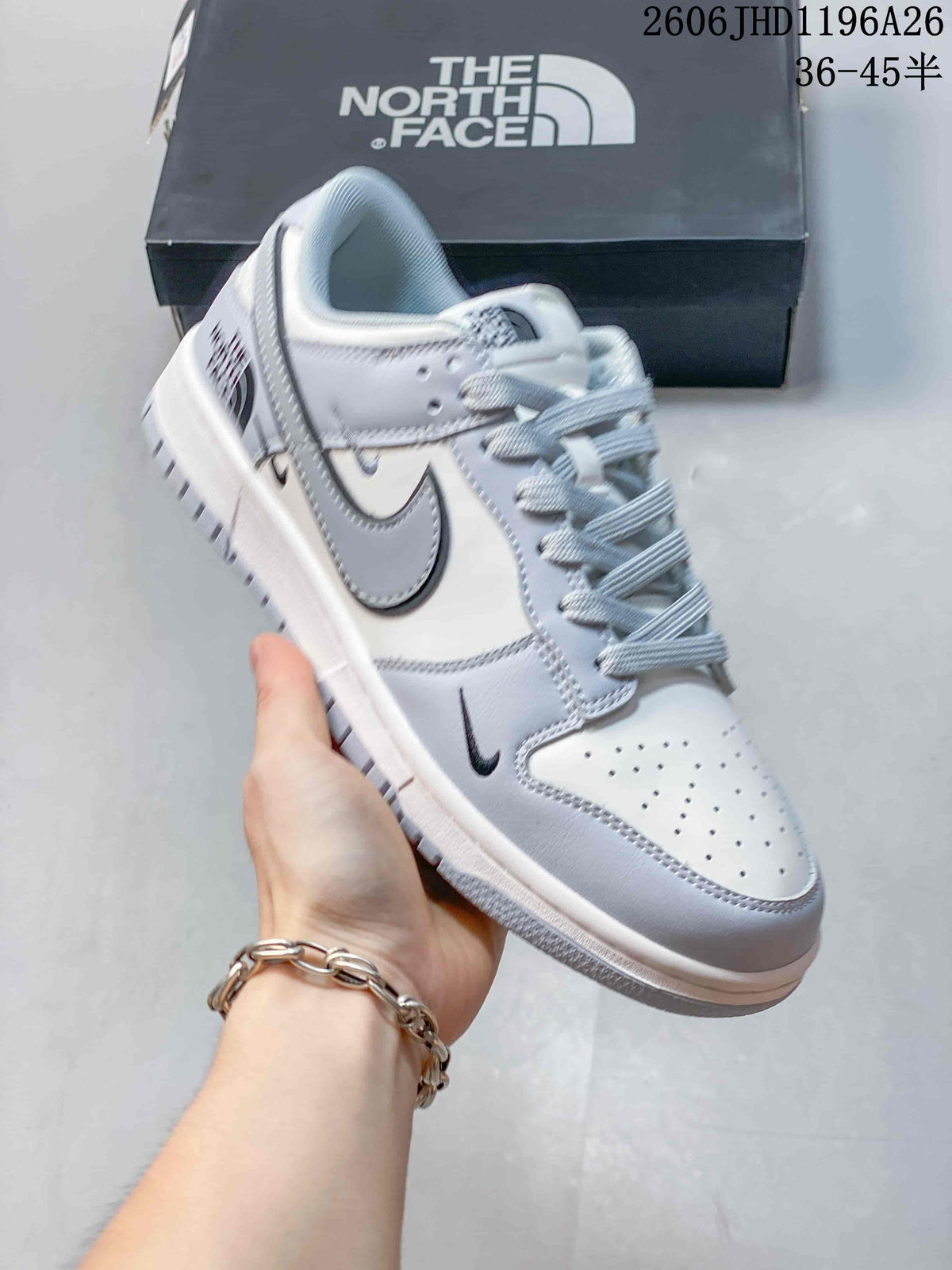 Angled view of a white and light gray low-top sneaker with visible side and heel branding.