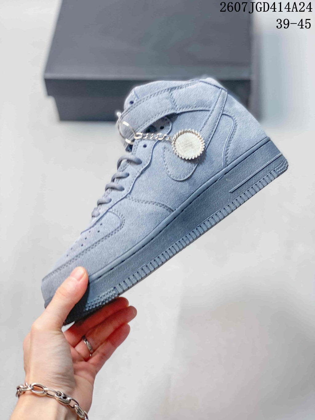 Side profile of the gray high-top sneaker showing the Swoosh detail, ankle strap, lace-up front, and raised sole.