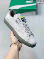 Angled side view of the white PUMA sneaker showing BMW Motorsport text, PUMA branding, gray accents, and the textured outsole.