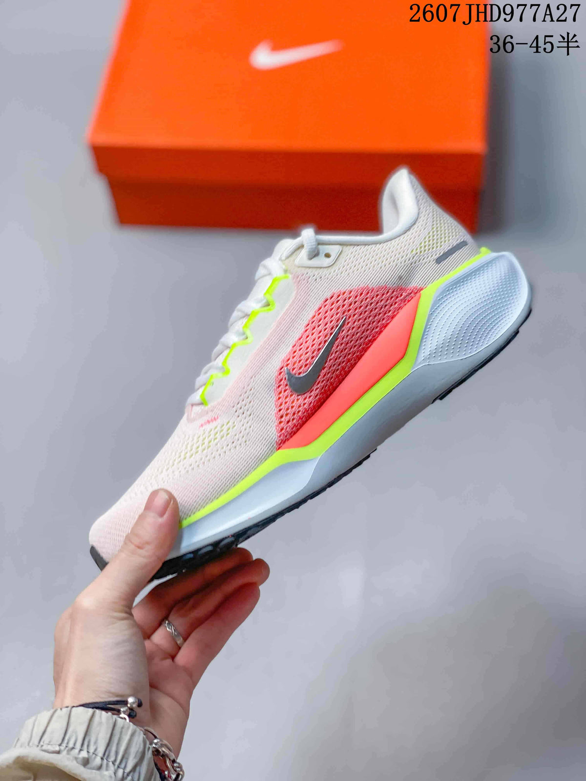 Side view of the low-top running shoe showing the pink mesh-look upper, coral side panel, gray Swoosh, and white midsole.