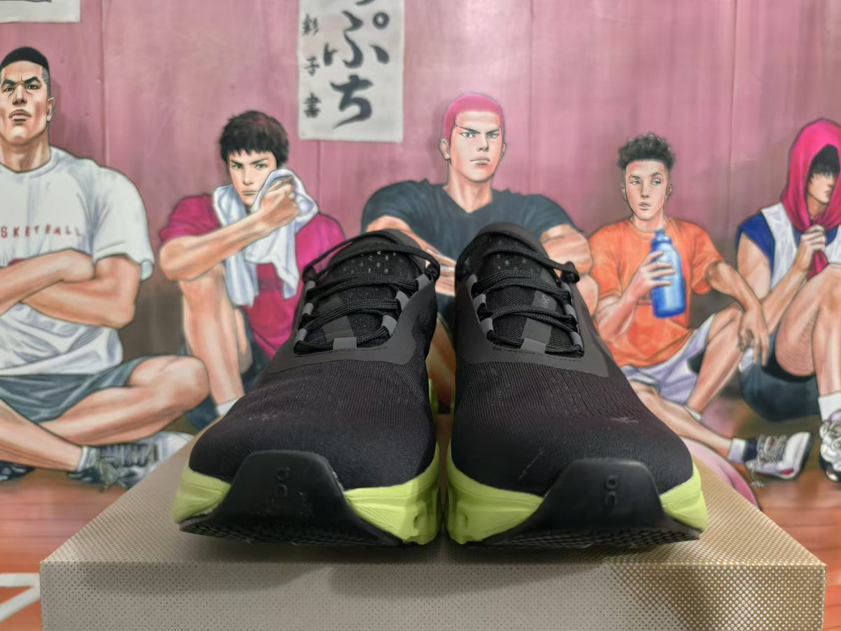 Front view of black lace-up sneakers with lime-green soles