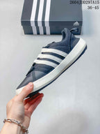 Side view of the navy and white shoe showing the mesh upper, three white stripes, laces, and contrasting midsole.
