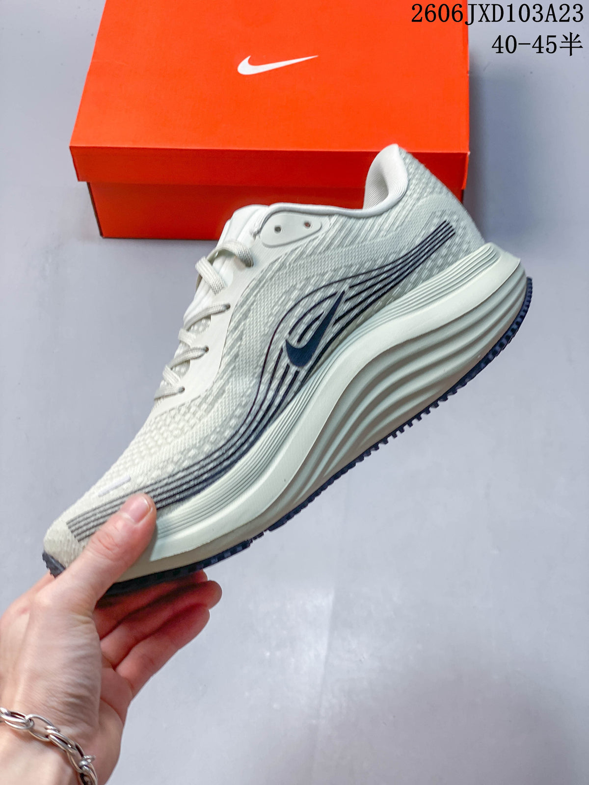 Side view of the light gray running shoe with dark graphics and a sculpted midsole