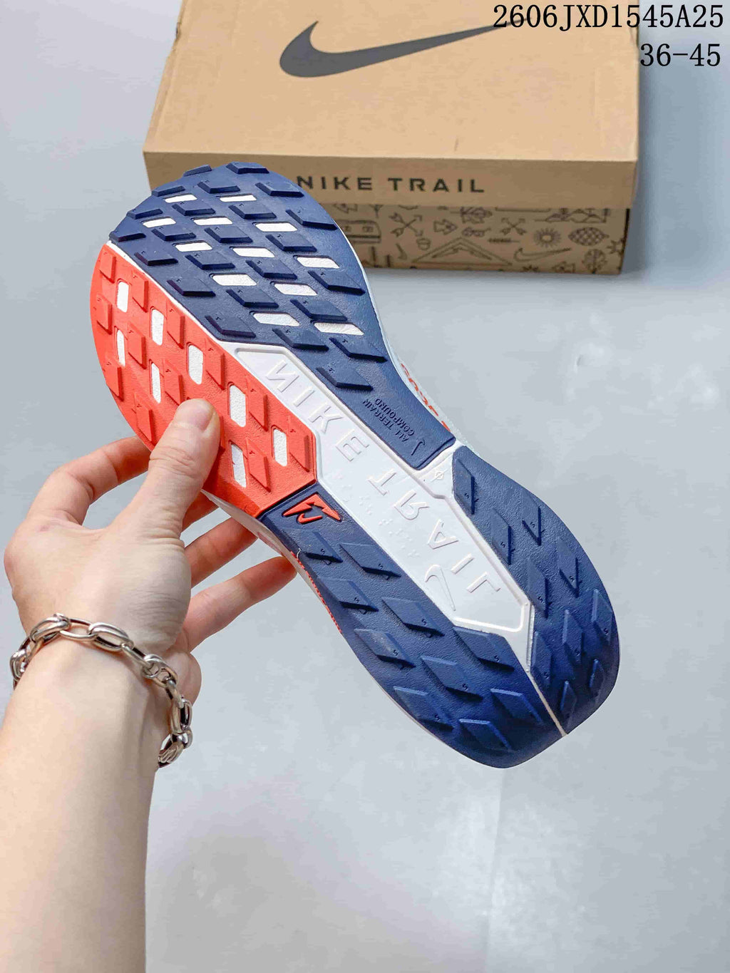 Close-up of the Nike Pegasus Trail outsole with dark blue and orange tread sections