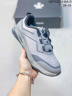 Angled side view of the gray and white DESCENTE sneaker showing the BOA dial, mesh-like upper panels, and layered sole.