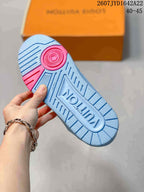 Underside of a light blue sneaker showing the textured rubber outsole, pink circular accent, and molded Louis Vuitton branding.