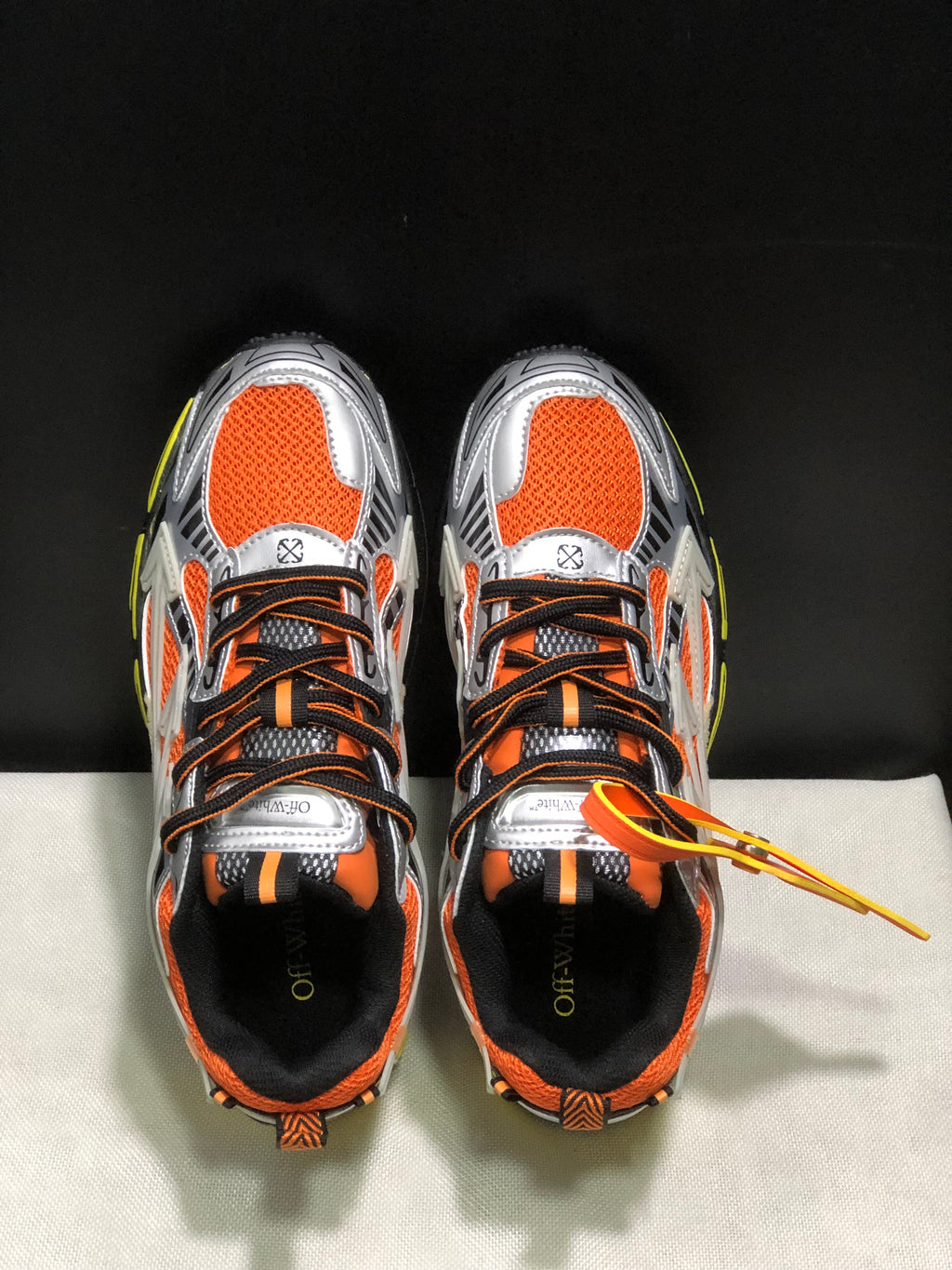 Top view showing the orange toe panels, black-and-orange laces, silver overlays, and branded insoles.