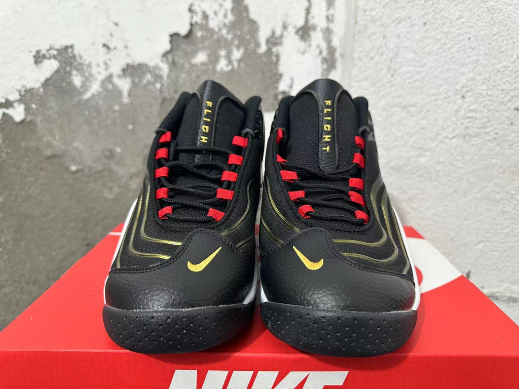 Front view of black Nike Flight sneakers with red lace loops and gold Swoosh details.