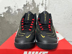Front view of black Nike Flight sneakers with red lace loops and gold Swoosh details.