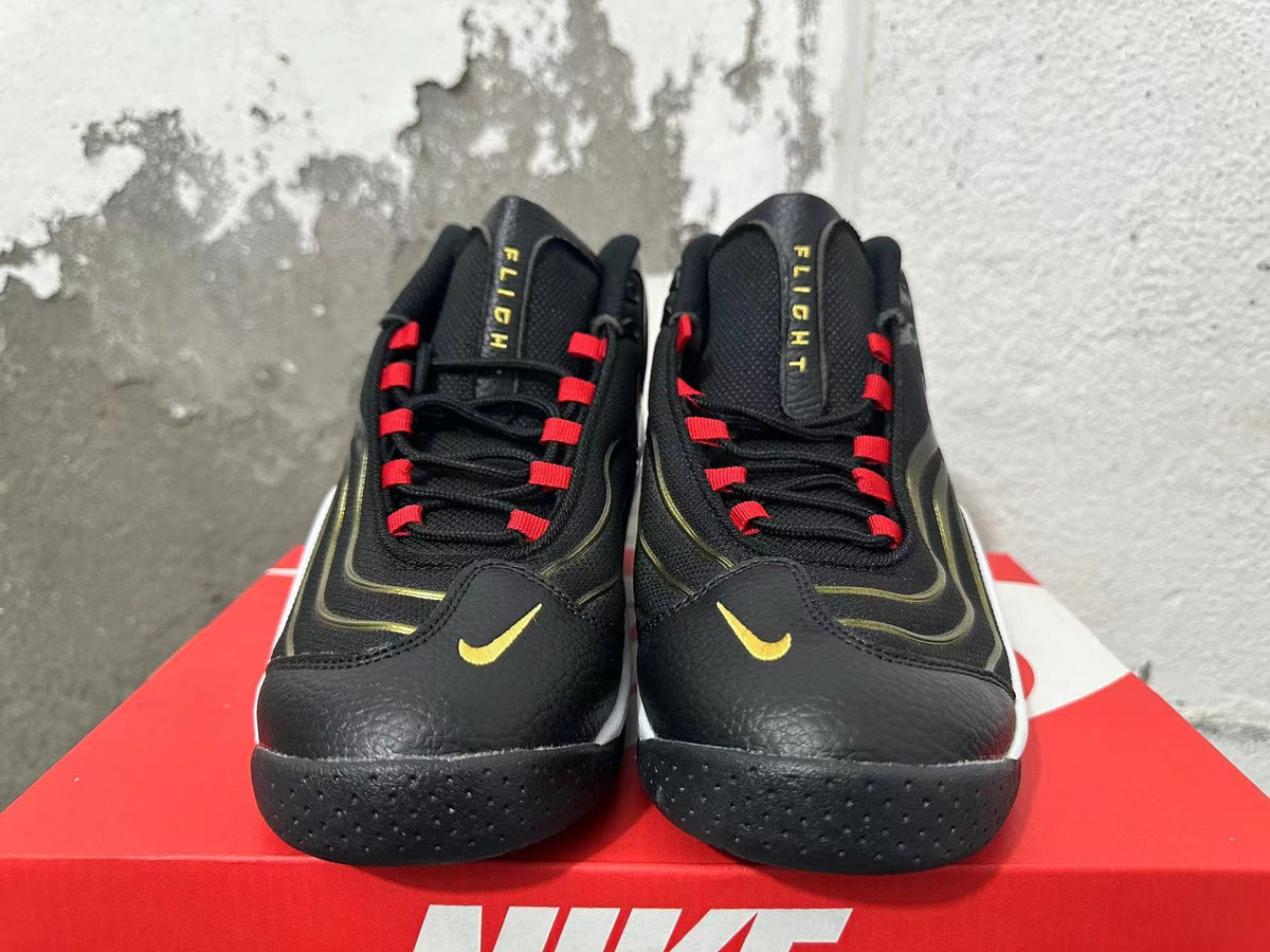 Front view of black Nike Flight sneakers with red lace loops and gold Swoosh details.