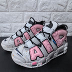 Pair of pink and grey sneakers with prominent AIR lettering and black laces