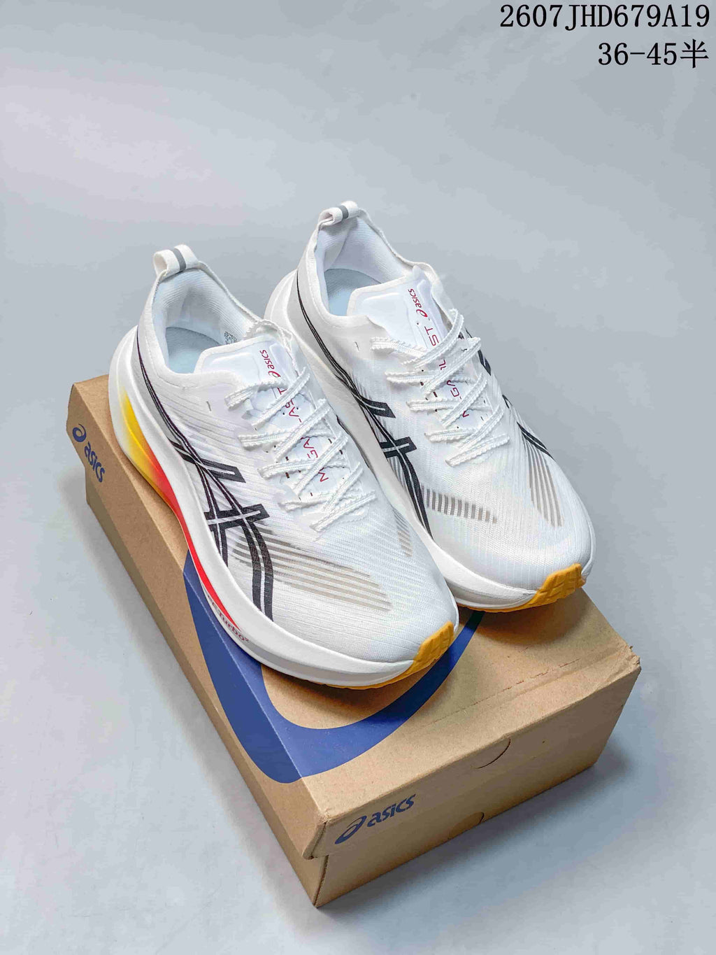 Pair of white ASICS Superblast 2 Paris running shoes displayed on an ASICS shoebox, showing black branding and yellow outsole accents.