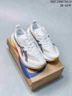 Pair of white ASICS Superblast 2 Paris running shoes displayed on an ASICS shoebox, showing black branding and yellow outsole accents.