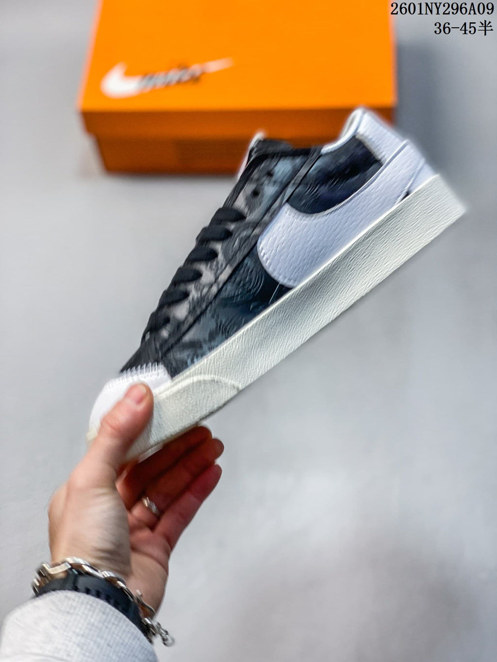 Side view highlighting the oversized white Swoosh, black upper, and cream-colored sole.