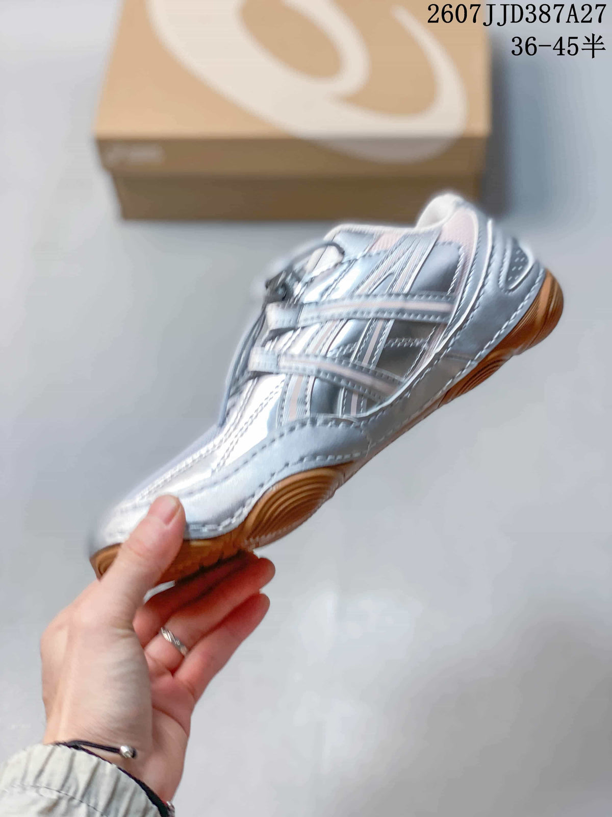 Side profile of the silver low-top sneaker showing layered overlays, laces, and the low-profile outsole.