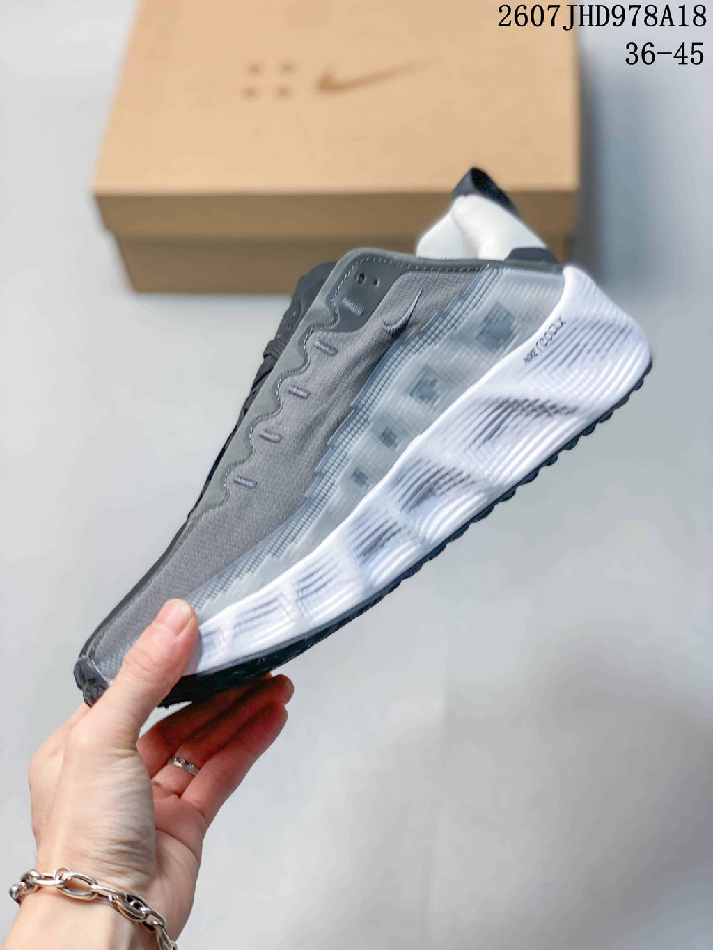 Side profile showing the gray upper, red Swoosh, sculpted white midsole, and black outsole.