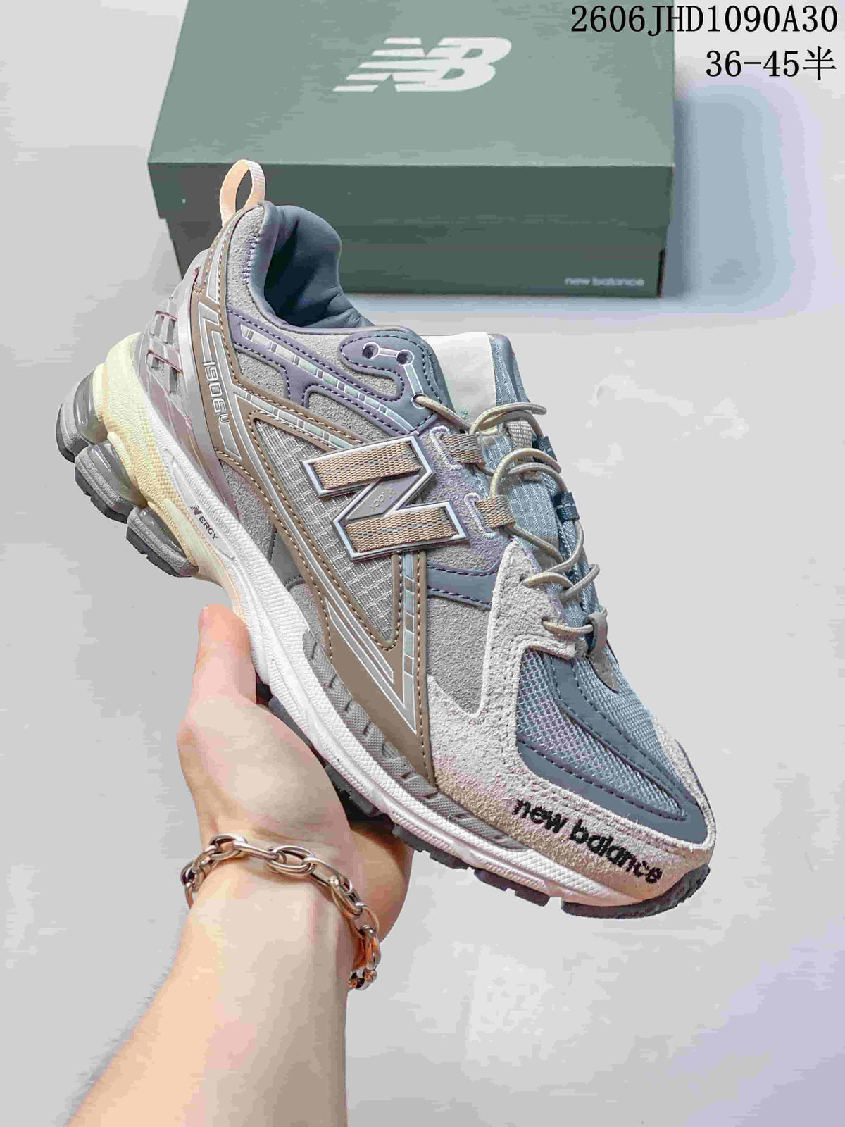 Gray and lilac New Balance M1906R sneaker with layered panels and segmented sole
