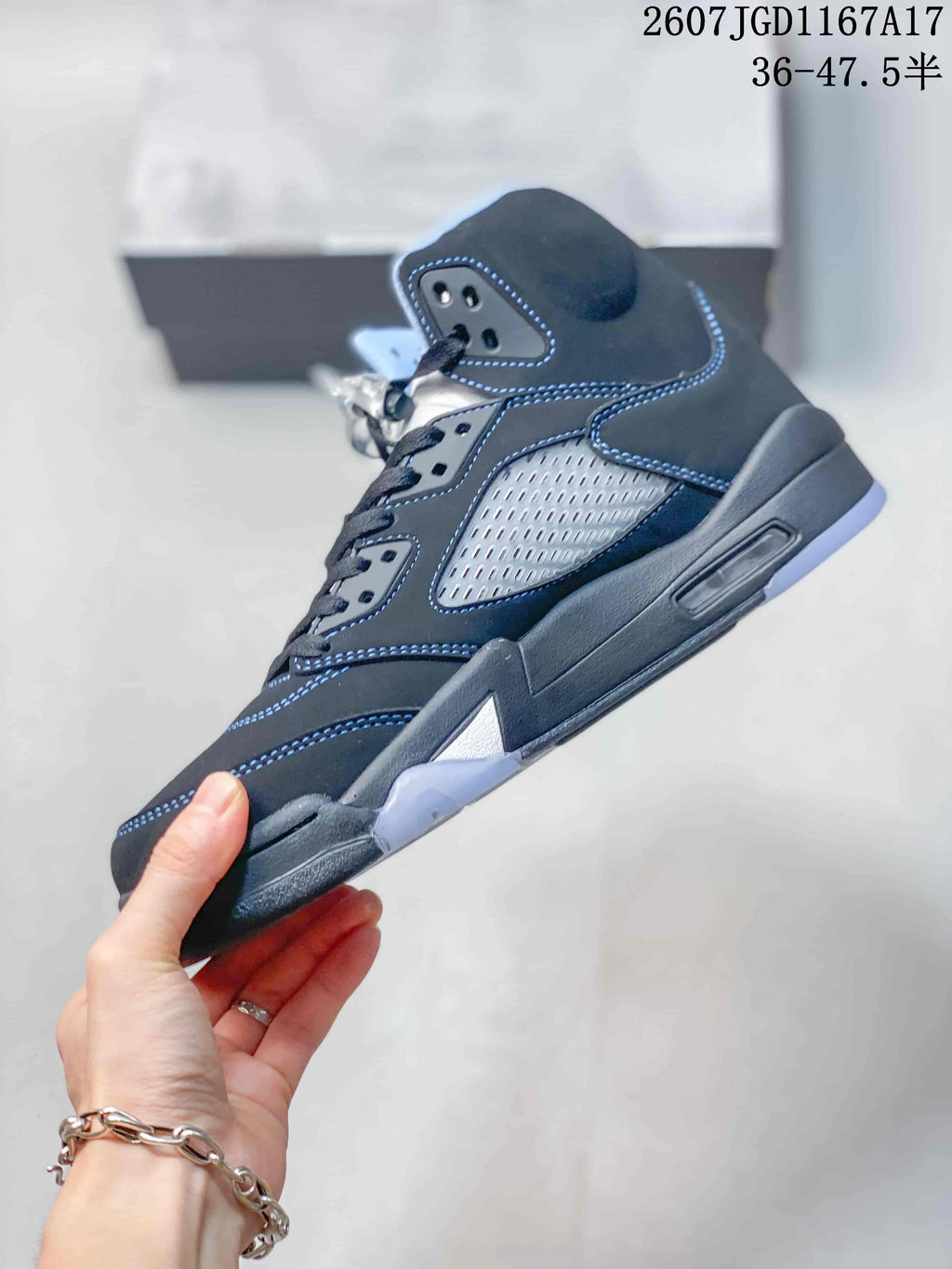 Side profile of the black high-top sneaker showing the mesh side panel, lace eyelets, layered midsole and translucent outsole.