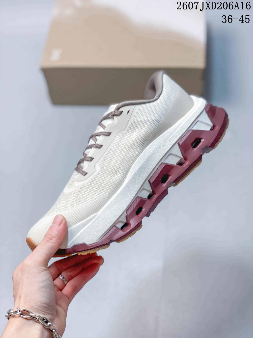 Side view highlighting the white mesh-style upper, sculpted midsole and burgundy outsole sections.