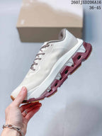 Side view highlighting the white mesh-style upper, sculpted midsole and burgundy outsole sections.