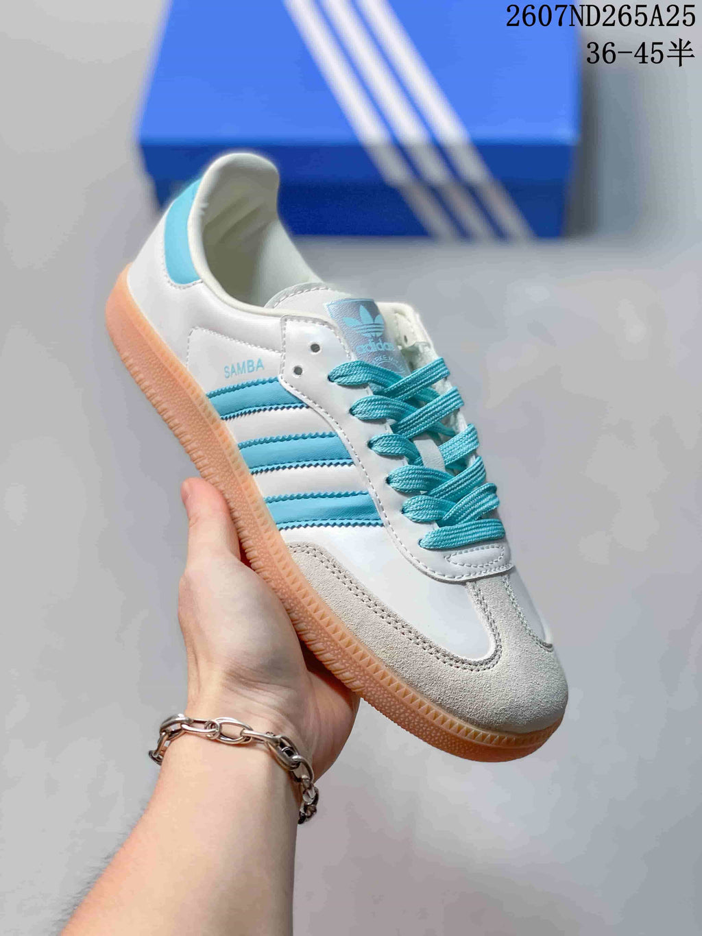 Side view of a white adidas Samba sneaker with aqua three-stripe detailing and a gum-toned outsole.