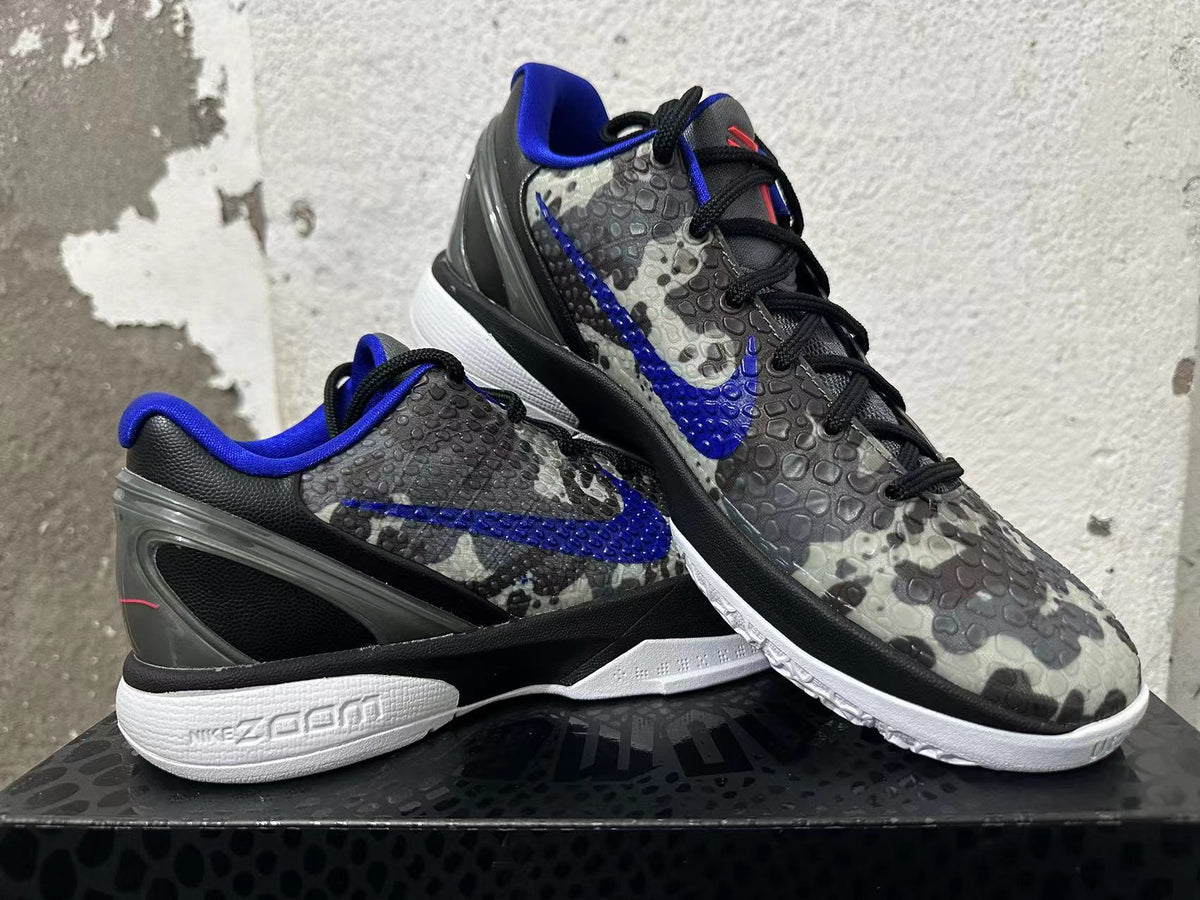Pair of gray camouflage Nike basketball shoes arranged to show the blue Swoosh, black laces, and white soles.