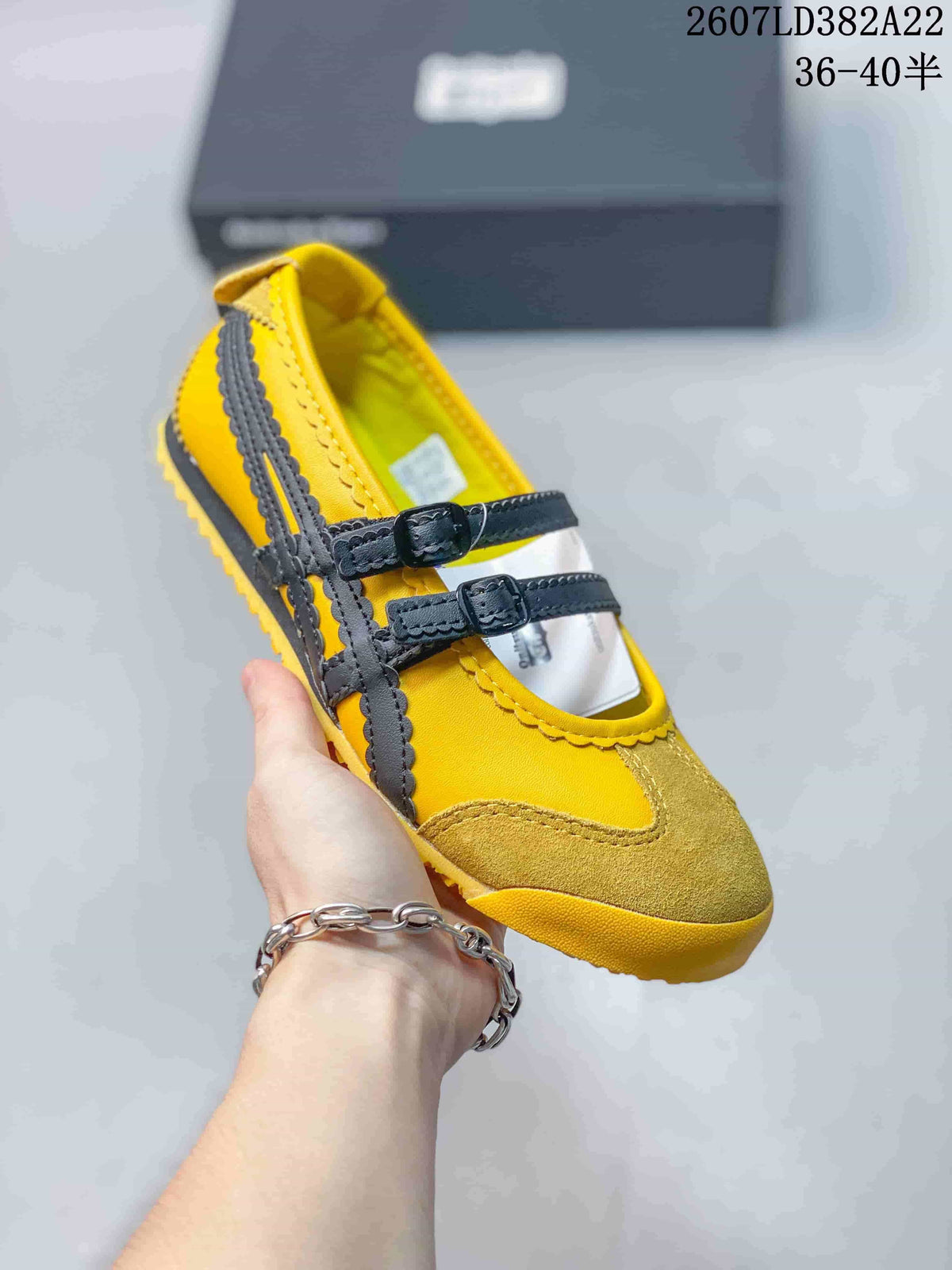 Close view of the yellow and black shoe showing the suede-textured toe area and dark buckle straps.