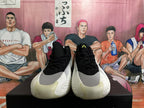 Front view of black basketball shoes with gray and white toe panels and lime tongue detail