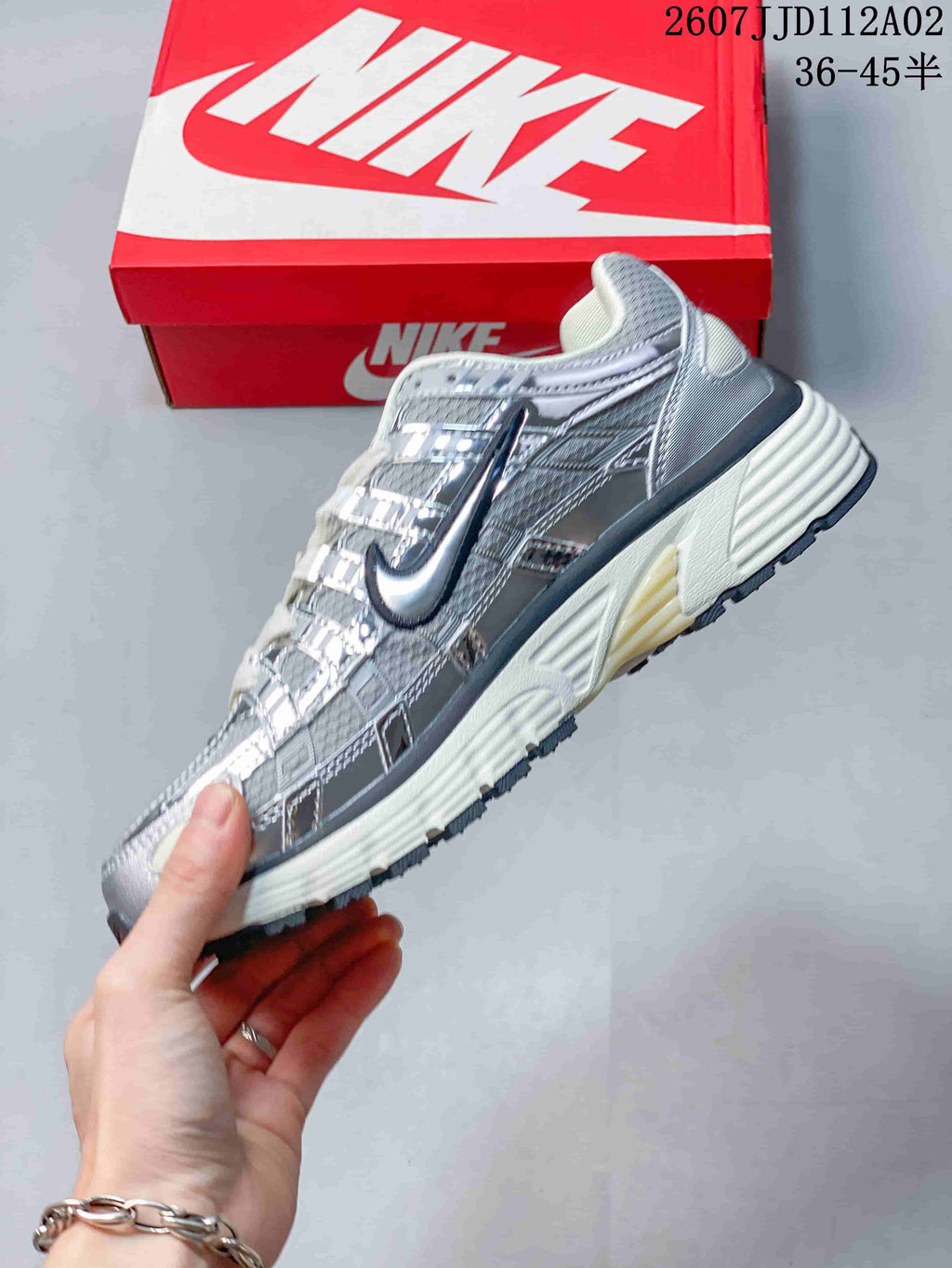 Side view of a silver-toned Nike P-6000 sneaker with layered panels