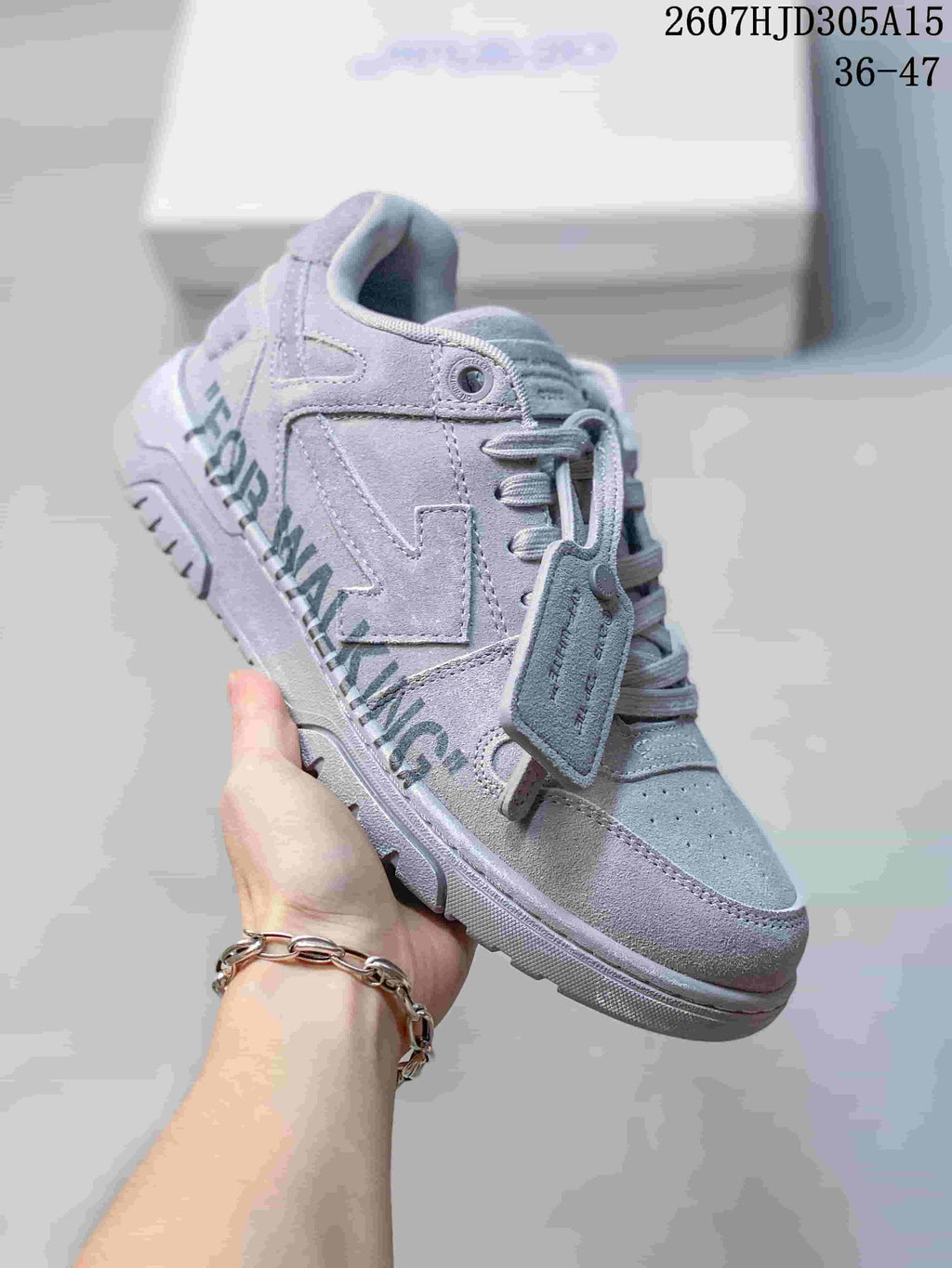 Angled side view of the gray sneaker showing the layered side design, graphic lettering, lace system, and low-top shape.