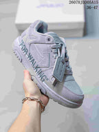 Angled side view of the gray sneaker showing the layered side design, graphic lettering, lace system, and low-top shape.