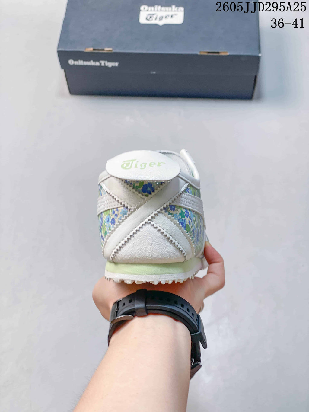 Rear view showing the white heel, green floral panels, and Onitsuka Tiger branding.