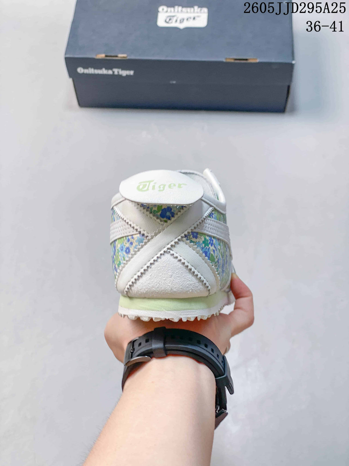 Rear view showing the white heel, green floral panels, and Onitsuka Tiger branding.