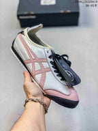 White low-top sneaker with pink accents, black laces, and a contrasting toe overlay