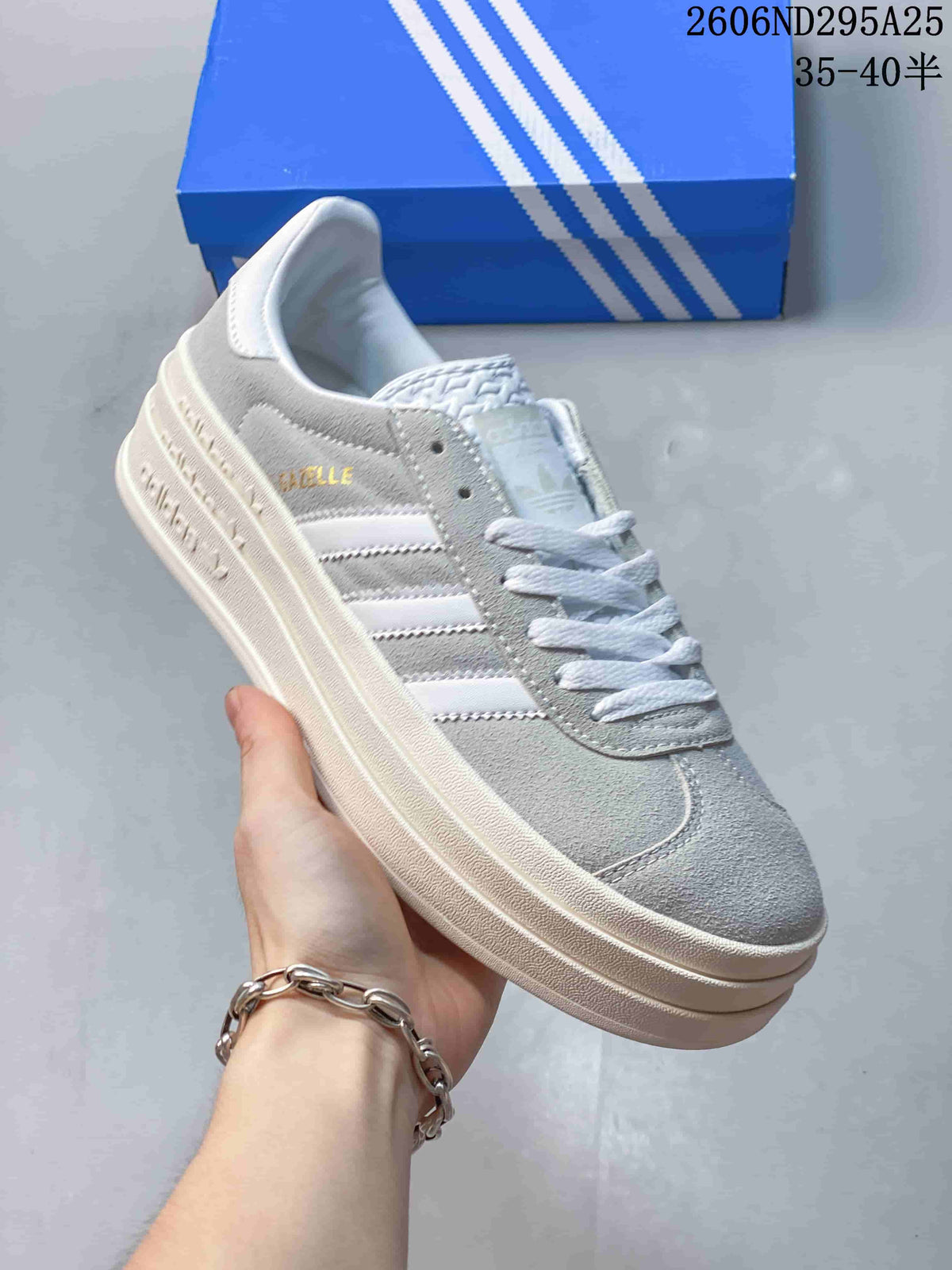 Light gray low-top sneaker with white stripes and laces and a light-colored platform sole