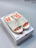 Pair of light-colored Nike Mind 001 slide sandals with orange footbed details on a shoebox