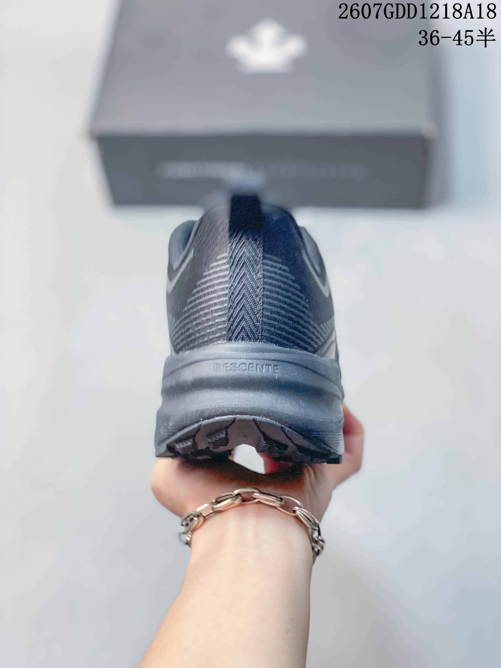 Rear view showing the padded heel collar, heel pull tab, and DESCENTE branding on the midsole.