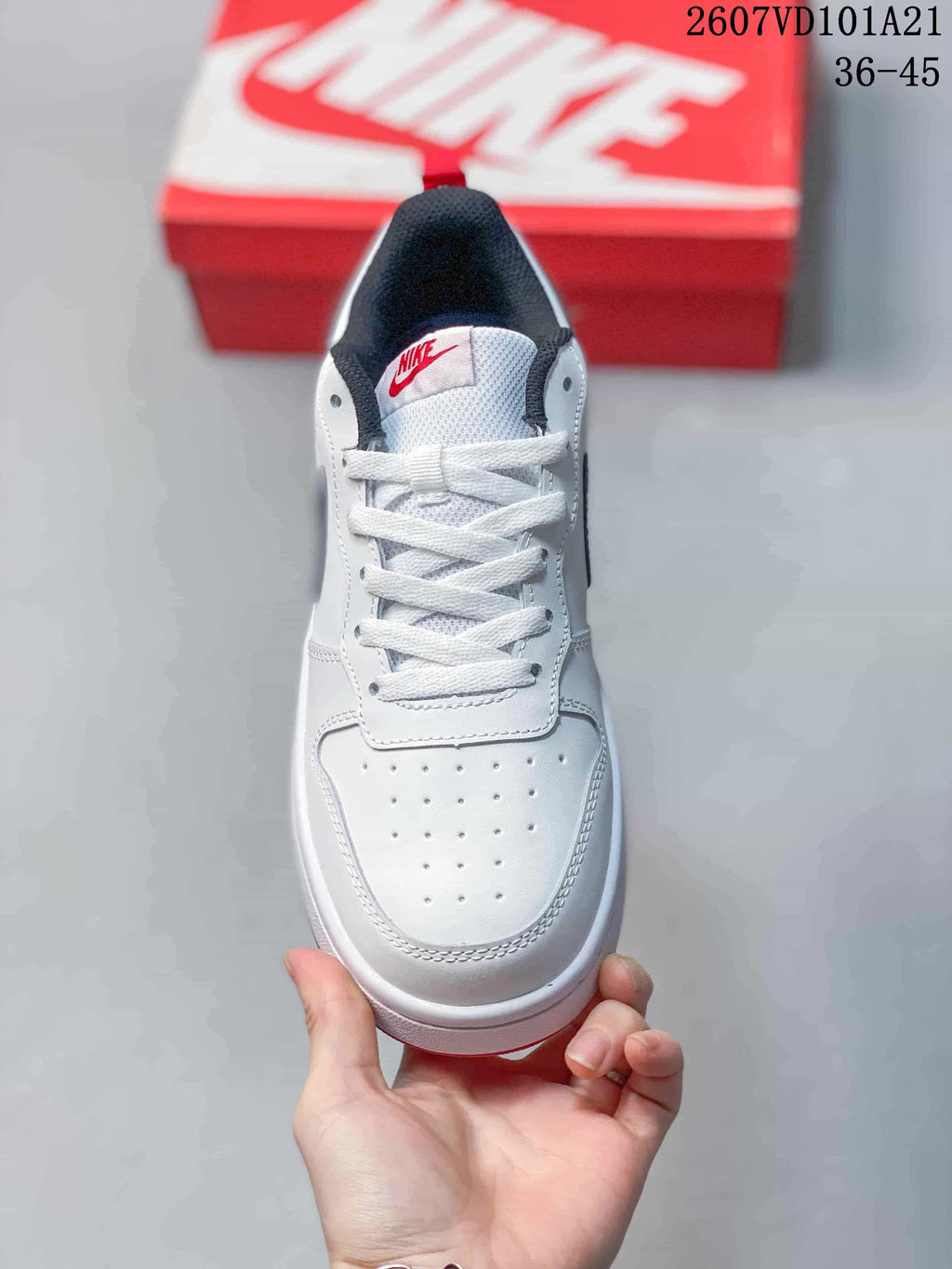 Top view of the white lace-up sneaker showing the perforated toe area, tongue label and dark collar.