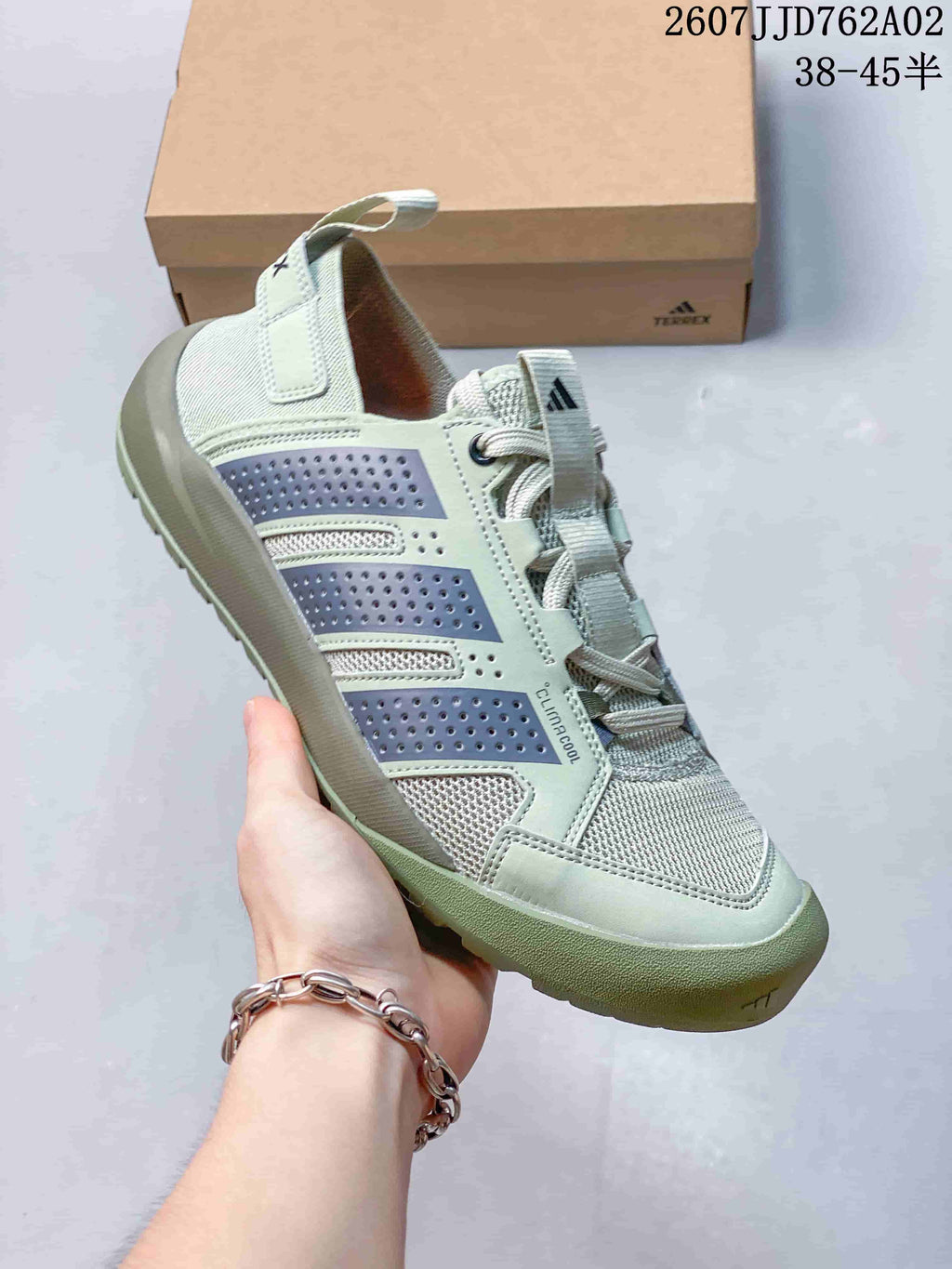 Angled side view of the sage green and gray outdoor shoe