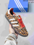 Angled side view of the leopard-print adidas Samba ADV sneaker with white stripes and red laces.
