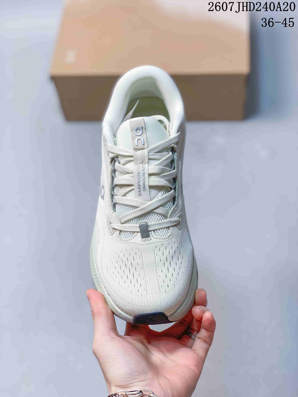 Front view of a white lace-up sneaker showing the perforated toe area, tongue and laces.