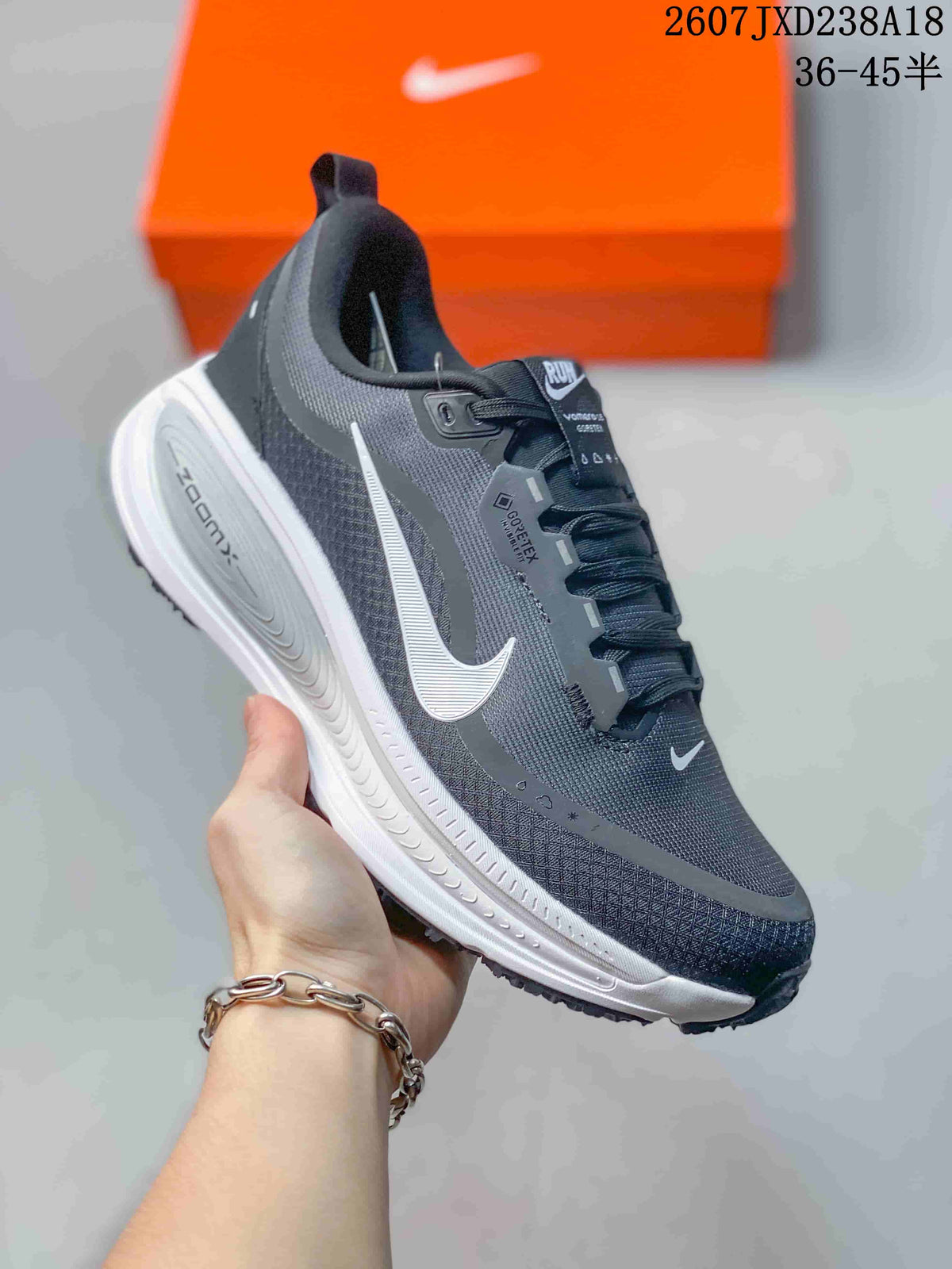 Angled side view showing the dark gray upper, white Swoosh, white sculpted midsole, and black outsole.