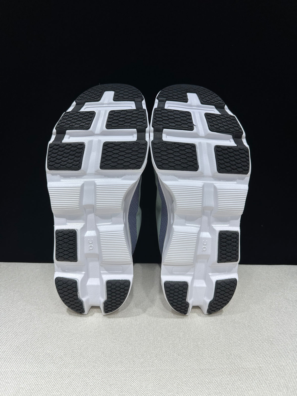 Bottom view showing white outsoles with black tread sections.